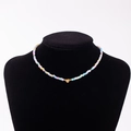 Rainbow seed bead necklace with gold heart pendant and Y initial on a black display stand - Letter Y