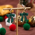 Orecchini a fiocco verde opaco natalizi con perni dorati su un supporto decorativo - Fiocco Verde Perlina Rotonda