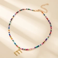 Collier de perles colorées avec pendentif lettre E dorée orné d'un petit cristal - Style Lettre E (E)