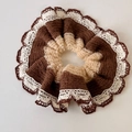 Détail d'un chouchou au crochet fait main marron et crème avec bordure en dentelle - Marron
