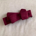 Detalle de una pinza para el pelo con lazo multicapa de terciopelo burdeos sobre lino - Rojo