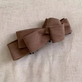 Detail view of multi-layered brown suede bow banana hair clip with secure black comb teeth - Brown