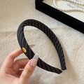 Detail of black twill sponge headband featuring a gold 'Hand Made' metal tag - Black