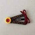 Détail de la pince à cheveux à carreaux vintage avec boutons et nœud en ruban rouge - Clips BB