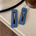 Nahaufnahme von dunkelblauen Denim-Haarspangen mit feinen Nähten und mattem Metall - Denim Rechteck Stil