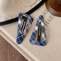 Macro detail of navy blue and white plaid BB hair clips on a vintage textured background - Plaid Triangle Style