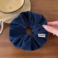Dettaglio dell'elastico in velluto blu scuro con etichetta handmade su legno - Blu
