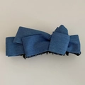 Dettaglio del fermaglio per capelli in denim blu con fiocco strutturato e denti neri forti - Azzurro