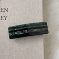 Detail of a dark green marble texture rectangle hair clip with gold France Handmade logo - Ink Wash Green