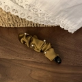 Nahaufnahme der Vintage braun Satin Bananen-Haarklammer mit Perlen auf Holz-Hintergrund - Braun