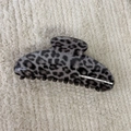 Detail view of large grey leopard print hair claw clip on neutral beige fabric - Gray Leopard-Curved
