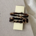 Detailed view of wave-edged acetate hair clips with tortoiseshell pattern on card - Tortoise