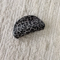 Detail view of a vintage leopard print hair claw clip in grey and black resin on a soft fabric - Gray Leopard-Semicircle