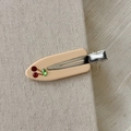 Détail d'une barrette en acétate crème ornée d'un motif cerise en strass sur tissu - Blanc Lait