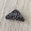 Detail view of triangular leopard print hair claw clip on soft white textured fabric - Gray Leopard-Triangle