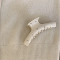 Close-up of cream acetate hair claw clip with sparkling rhinestones on knit fabric - Cream White Bar Style
