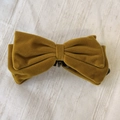 Dettaglio del fermaglio per capelli a fiocco in velluto senape con trama pregiata - Giallo