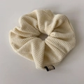 Detailed macro view of the cream knit scrunchie texture with a black woven label - Off-white