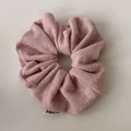 Dettaglio dell'elastico scrunchie in maglia rosa glitterata con trama metallica e etichetta - Rosa