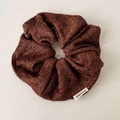Dettaglio ravvicinato dell'elastico scrunchie marrone scuro glitter con etichetta FMdrea - Marrone