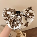 Dettaglio della molletta per capelli in raso bianco con stampa floreale vintage e stile - Beige