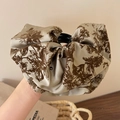 Dettaglio di elegante fermaglio in raso floreale con texture in seta vintage - Marrone