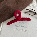 Detalle de pinza para el pelo en terciopelo rojo sobre un libro para estilo elegante - Rojo