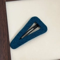 Detail of teal blue wool fabric hair clip with a minimalist triangular hollow design - Blue