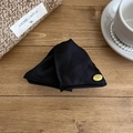 French style black fabric shell hair claw with gold logo on a rustic wooden table - Black