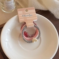 Detailed shot of three spiral hair ties with star and heart charms in a ceramic bowl - Three-Piece Set / Pink Series