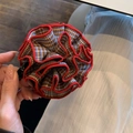 Dettaglio della trama a quadri rossi e delle cuciture sulla clip per capelli a fiore - Quadri con Bordo Rosso