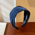 Detalle de una diadema ancha de terciopelo azul marino con textura suave y forro - Azul