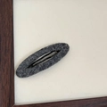 Detailed view of the gray felt fabric texture on the minimalist oval BB hair clip - Dark Gray Oval