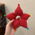 Dettaglio dell'elastico per capelli a stella rossa con pois bianchi e pompon colorati - Rosso