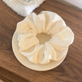 Détail d'un chouchou tricoté blanc crème à texture ajourée posé sur une assiette - Grand / Blanc Cassé