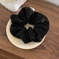 Gros plan d'un chouchou noir en maille tricotée avec étiquette sur assiette céramique - Grand / Noir