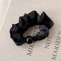 Detalle de un coletero plisado negro con costuras blancas y una cuenta negra brillante - Natural Con Borde Negro
