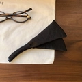 Details einer eleganten schwarzen Satin-Haarklammer auf Holz- und Leinenoberfläche - Schwarz