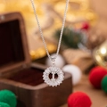 Silver tone necklace with full zircon letter I pendant over a dark wooden gift box - Letter I