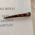 Close-up of a long leopard print hair clip on a minimalist textured beige background - Dark Leopard Thin Straight Style