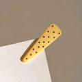 Detalle de pinza triangular amarilla con lunares rojos sobre papel blanco con textura - Amarillo