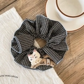 Close-up of checkered scrunchie featuring a cute 3D cat plush doll with lace collar - Black Plaid