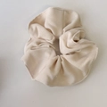 Detail van een crèmekleurige geribbelde scrunchie met zachte textuur en elastisch ontwerp - Off-wit