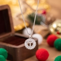 Silver pendant necklace featuring letter T with zircon stones and festive gift background - Letter T