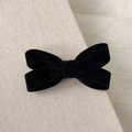 Detalle de la pinza para el pelo con lazo de terciopelo negro sobre fondo de lino - Negro