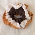 Close-up of ginger floral scrunchie with white lace embroidery and cotton texture - Orange Lace Style