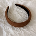 Primer plano detallado de la diadema de terciopelo marrón con un diseño ancho y minimalista - café