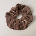 Detail showing deep brown polka dot scrunchie with textured linen fabric and handmade label - Coffee