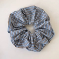 Dettaglio di un elastico per capelli a quadretti blu con trama di cotone e piccola etichetta - Scrunchie Blu