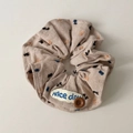 Macro view of brown polka dot scrunchie with Nice Day tag and decorative button - Khaki Button Scrunchie